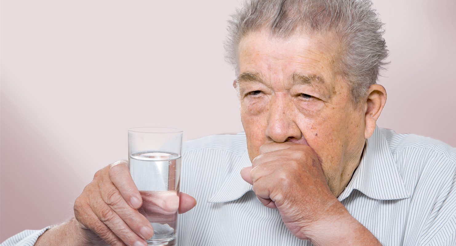 Älterer Mann mit Glas in der Hand